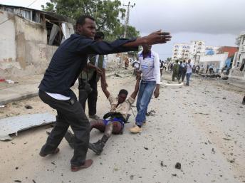 Des civils évacuent un blessé après l'attaque qui a visé des locaux des Nations unies à Mogadiscio. REUTERS