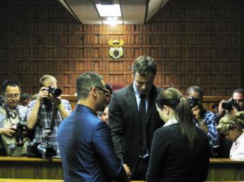 Oscar Pistorius pleure et prie avec son frère Carl et sa soeur Aimée, juste avant l'audience de confirmation des charges de meurtre et de détention d'arme illégale, le 19 août 2013. Sonia Rolley/RFI
