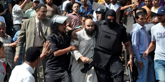 La police escorte un partisans des Frères musulmans hors de la mosquée. | AP