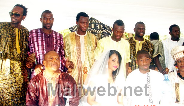 le couple posant avec Vieux Pathé Diallo et les joueurs de l'équipe nationale