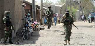 Des soldats marchent dans les rues de Baga (Nigeria), le 30 avril 2013. (PIUS UTOMI EKPEI / AFP)