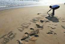 Sur la plage de Grand-Bassam, un homme écrit dans le sable «Je dis non au terrorisme», le 16 mars 2016. © SIA KAMBOU / AFP