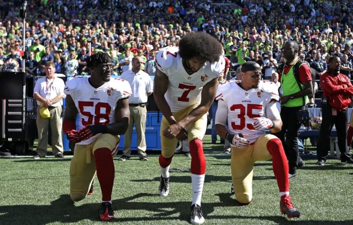 Les joueurs des 49ers de San Francisco, Eli Harold, Colin Kaepernick et Eric Reid protestent pendant l'hyme américain, le 25 septembre 2016.