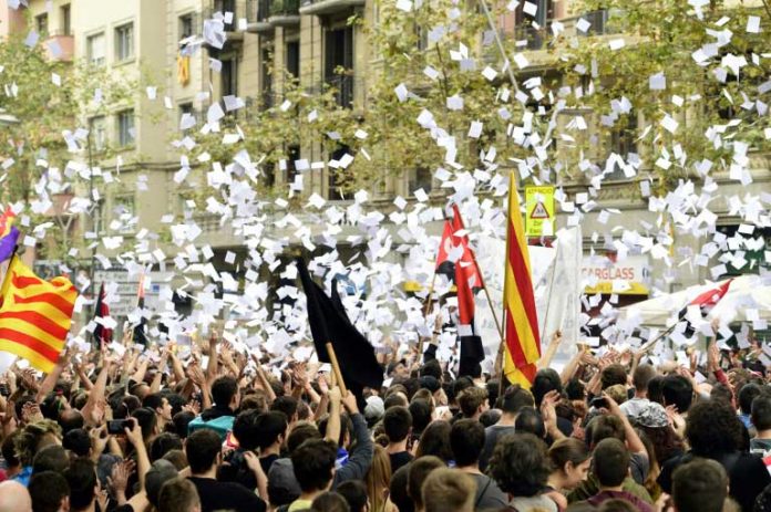 Des manifestants en faveur de l'indépendance de la Catalogne jettent des bulletins de votent en l'air, le 3 octobre 2017 à Barcelone / © AFP / PIERRE-PHILIPPE MARCOU