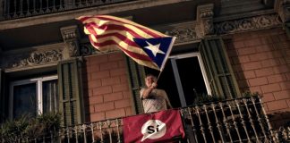 Un homme brandit un drapeau catalan après le référendum d'autodétermination de la Catalogne à Barcelone, le 1er octobre 2017 / © AFP / PAU BARRENA