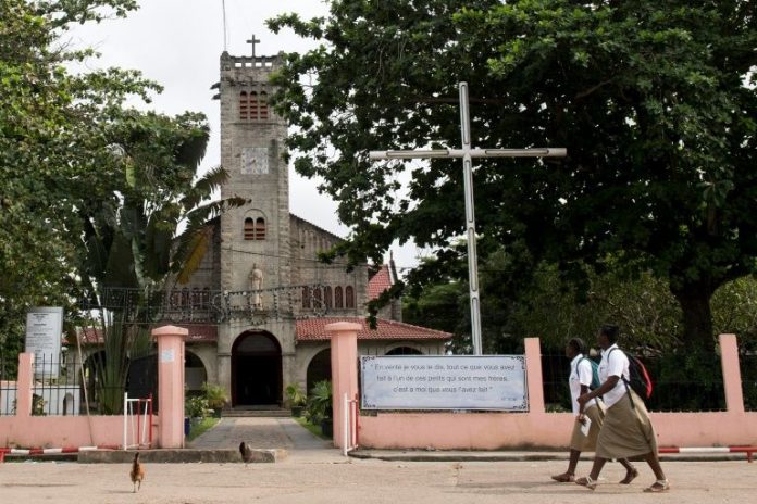 Des écolières passent devant la cathédrale Saint-Louis à Port-Gentil au Gabon, le 18 janvier 2017