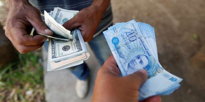 Echange de dollars contre des dinars au marché noir, à Tunis, en août 2017. CRÉDITS : ZOUBEIR SOUISSI/REUTERS