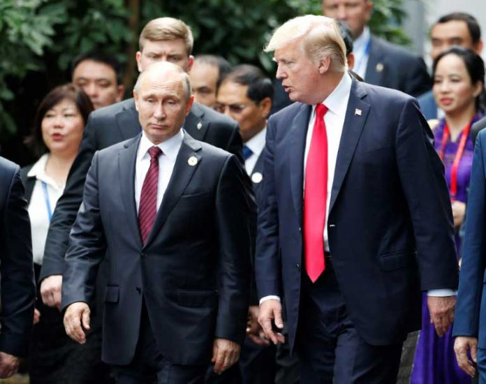 Le président américain Donald Trump et son homologue russe Vladimir Poutine échangent quelques mots, en marge du sommet de l'APEC à Danang, le 11 novembre 2017 / © POOL/AFP / JORGE SILVA