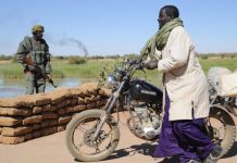 Un Malien pousse sa moto au passage d'un checkpoint dans la région de Gao en 2013