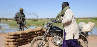 Un Malien pousse sa moto au passage d'un checkpoint dans la région de Gao en 2013