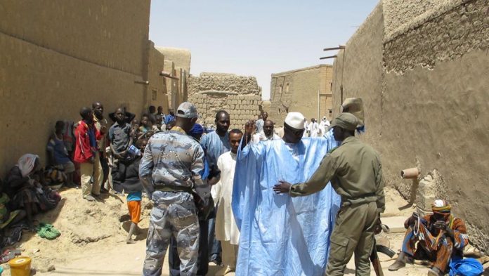 Des militaires maliens contrôlent des habitants de la ville de Tombouctou, avril 2014.