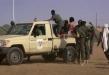 Des soldats se rassemblent près d'un pick-up après l'attaque kamikaze qui a ensanglanté un camp de Gao, au Mali, le 18 janvier 2017.