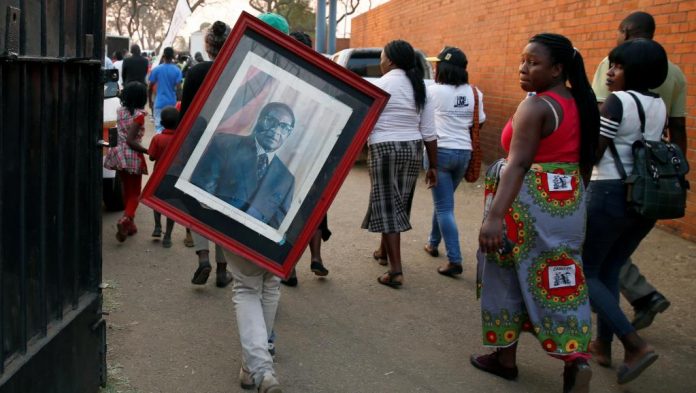 Des supporteurs du président défunt Robert Mugabe quittent le stade Rufaro